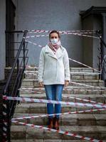 foto van een meisje met een masker. op straat staan met waarschuwingsbanden voor gevaar.