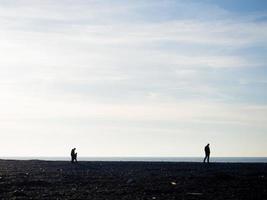 mensen Aan de voorjaar kiezelsteen strand Bij zonsondergang. vakantie Aan de strand. rust uit Aan de zee. rotsachtig oever. kiezelsteen strand. foto