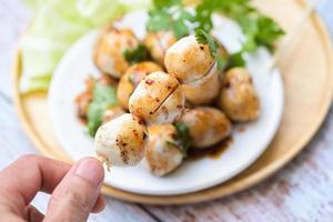 gehaktballen Aan hand- met met pittig saus, gegrild gehaktbal en varkensvlees bal, vlees bal Aan spiesjes en vers koriander groenten, Thais voedsel Aziatisch voedsel vlees ballen - varkensvlees ballen foto