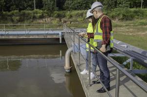 milieu-ingenieurs werken bij afvalwaterzuiveringsinstallaties, watervoorzieningstechniek werken bij waterrecyclinginstallaties voor hergebruik, technici en ingenieurs bespreken samenwerking. foto