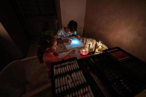 familie uitgeven tijd samen gedurende een energie crisis in Europa veroorzaken black-outs. kinderen tekening in Black Out. foto