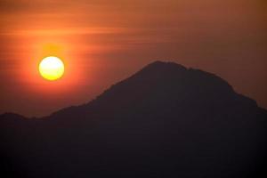 de zon stijgt achter de berg 1 foto