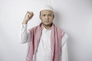jong Aziatisch moslim Mens gevoel echt en focus staren Bij camera terwijl verhogen zijn hand- foto