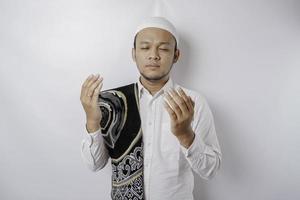 gelukkig knap Aziatisch moslim Mens met gebed tapijt Aan zijn schouder is bidden naar god. foto