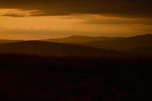zonsondergang in de wild, berg schemering oranje licht, landschap foto