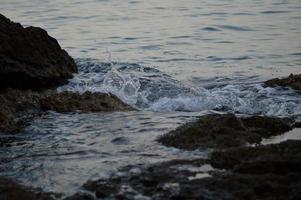zee golven crashen in rotsen foto