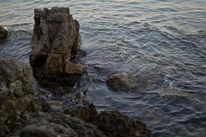 rotsen Bij de strand, kalmte water foto