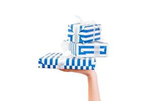 vrouw handen geven verpakt reeks van Kerstmis of andere vakantie handgemaakt Cadeau in blauw papier met wit lintje. geïsoleerd Aan wit achtergrond, top visie. dankzegging geschenk doos concept foto