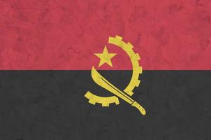 Angola vlag afgebeeld in helder verf kleuren Aan oud Verlichting bepleistering muur. getextureerde banier Aan ruw achtergrond foto