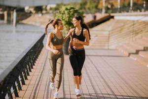 jonge vrouw die hardloopoefeningen doet aan de rivierpromenade foto