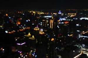 wazig kleurrijk licht van gebouw huis of huis, structuur, voertuig en vervoer in Bangkok stad Aan nacht voor achtergrond. abstract leven Aan Thailand land behang. foto