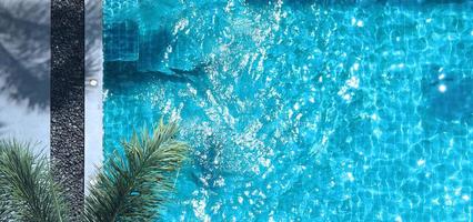 zwemmen zwembad blauw water in zomer en wit strand bedden en top visie hoek. foto