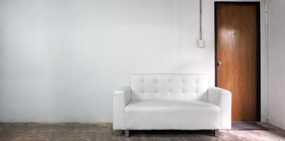 wit leer sofa en wit oud muur en oud hout deur in kamer. foto