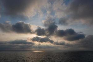 bewolkt zee keer bekeken van de Baltisch zee Bij zonsopkomst foto