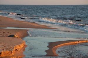 stenen Aan de kust van de Baltisch zee Bij zonsondergang foto