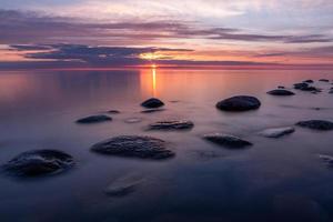 stenen Aan de kust van de Baltisch zee Bij zonsondergang foto