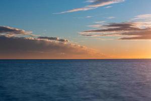 bewolkt zee keer bekeken van de Baltisch zee Bij zonsopkomst foto