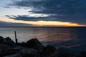 bewolkt zee keer bekeken van de Baltisch zee Bij zonsopkomst foto