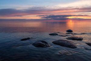 stenen Aan de kust van de Baltisch zee Bij zonsondergang foto