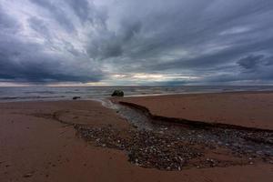 stenen Aan de kust van de Baltisch zee Bij zonsondergang foto