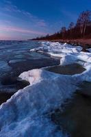 Baltisch zee kust in winter met ijs Bij zonsondergang foto
