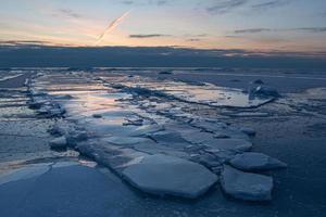 Baltisch zee kust in winter met ijs Bij zonsondergang foto