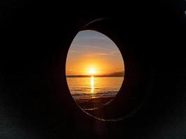 silhouet van voorwerpen Aan de strand met zonsopkomst foto