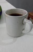 een kop van heet koffie Aan een wit tafel, traditioneel geserveerd. heel mooi zo heet koffie. foto