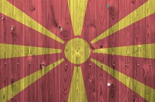 Macedonië vlag afgebeeld in helder verf kleuren Aan oud houten muur. getextureerde banier Aan ruw achtergrond foto