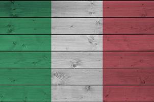 Italië vlag afgebeeld in helder verf kleuren Aan oud houten muur. getextureerde banier Aan ruw achtergrond foto