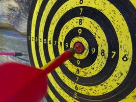 groot speelbaar geel en zwart dartbord of darts in de bar tegen de achtergrond van een houten muur foto