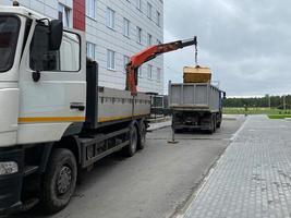 een groot, krachtig vuilnis vrachtauto lost vuilnis met een manipulator voor volgend recycling van middelen foto