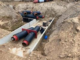 groot industrieel modern nieuw groot diameter polyethyleen plastic water pijpen liggen in een pit ondergronds Bij een bouw plaats gedurende een water pijp reparatie foto