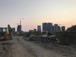 bouw verspilling Bij de plaats. onzin van concreet, bakstenen en andere bouw afval. een plaats voor opslaan vuilnis tegen de backdrop van een groot stad foto