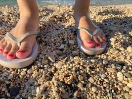 vrouw voeten met omdraaien flops Aan de strand foto