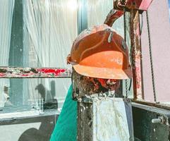 bouw van een nieuw microdistrict in de stad centrum. een oranje helm van een arbeider leugens Bij de bouw plaats. beschermend uniform voor de veiligheid van Bouwers Aan plaats foto