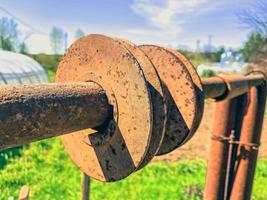 roestig uitrusting liggen in de land. een metaal stok leugens Aan de grond en is gedekt met corrosie. een ring blijft hangen Aan een roestig stok. oud ongewenst metaal structuur foto