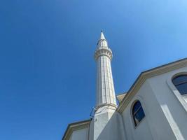 Islamitisch moskee nieuw modern wit Arabisch groot moslim voor gebeden met een hoog toren in een toerist warm tropisch oostelijk land zuidelijk toevlucht foto