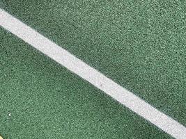 groen rubber oppervlakte van een tennis rechtbank antitraumatisch veiligheid tegel Aan een training sport- speelplaats in een openbaar park of binnenplaats. de achtergrond. structuur foto
