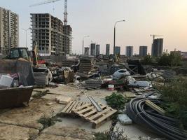 bouw verspilling leugens Bij de bouw plaats. de trekker transporten verspilling naar opslaan de milieu van onzin. bouw van een nieuw microdistrict in de stad centrum foto