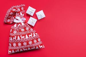 decoratief Kerstmis geschenk dozen, rood geschenk zak Aan rood achtergrond foto