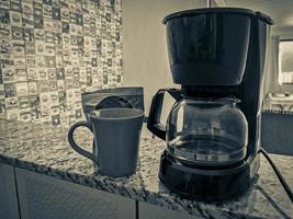 koffie machine en rood kop Aan tafel in de keuken. foto