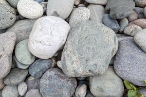 groot stenen van verschillend vormen Aan de oever van de rivier detailopname. Daar zijn een veel van klein stenen in de buurt. foto