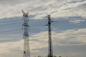 metaal torens, bouwkunde werken dat ondersteuning de koper kabels dat dragen elektriciteit. foto