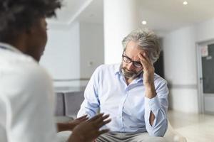 soort vrouw dokter omarmen bemoedigend gelukkig senior mannetje geduldig in ziekenhuis. gelukkig gezond ouder Mens en zijn arts genieten van praten. ouderen medisch Gezondheid zorg concept. foto