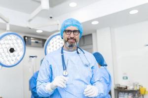 portret van mannetje chirurg staand in in werking kamer, klaar naar werk Aan een geduldig. mannetje medisch arbeider chirurgisch uniform in operatie theater. foto