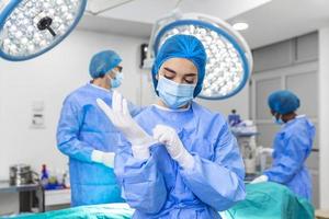 portret van vrouw vrouw verpleegster chirurg of personeel lid gekleed in chirurgisch scrubs japon masker en haar- netto in ziekenhuis in werking kamer theater maken oog contact glimlachen verheugd gelukkig op zoek Bij camera foto