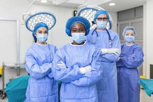 groep van medisch chirurgen vervelend ziekenhuis scrubs in in werking theater. portret van geslaagd medisch arbeiders in chirurgisch uniform in operatie theater, klaar voor De volgende operatie. foto