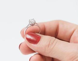 dichtbij omhoog van een elegant verloving diamant ring houden door Dames. foto