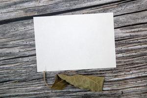a5 papier groet kaart mockup met droog bladeren Aan houten achtergrond foto